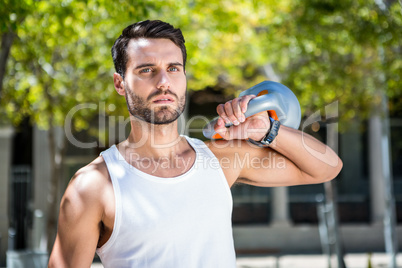 Handsome athlete outfit with a kettlebell