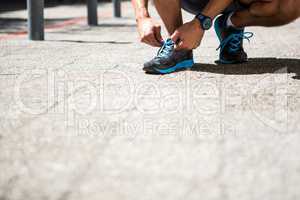 Athletic man tying his shoe laces