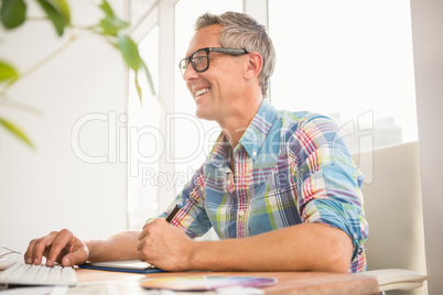 Smiling casual designer using computer and digitizer