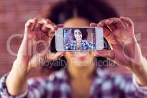 Attractive young woman taking selfies with smartphone