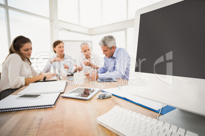 Electronic devices in front of talking business people