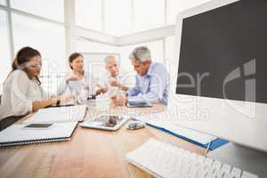 Electronic devices in front of talking business people