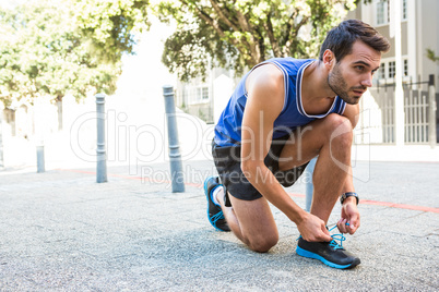 Handsome athlete tying his shoes