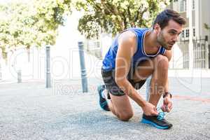 Handsome athlete tying his shoes