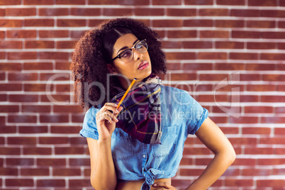 Daydreaming attractive hipster holding pen