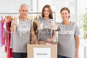Smiling volunteers showing donated cans