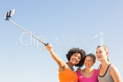 Smiling sporty women taking selfies with selfiestick Smiling sporty women taking selfies with selfiestick