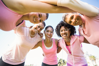 Women wearing pink for breast cancer with arms around