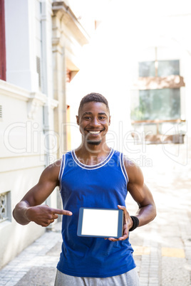 Smiling athletic man using tablet computer