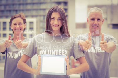 Smiling volunteers showing blank tablet