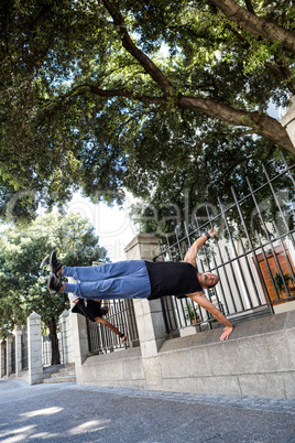 Happy friends doing parkour in the city