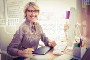 Smiling casual designer working at her desk