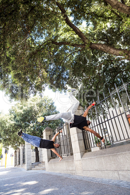 Happy friends doing parkour in the city