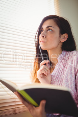 Pretty brunette studying beside window