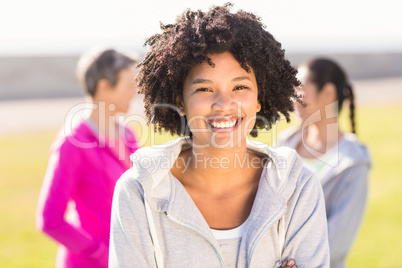 Smiling sporty woman in front of friends