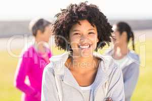 Smiling sporty woman in front of friends