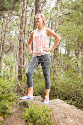 Smiling blonde hiker standing on rock