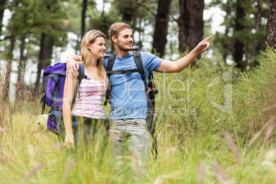 Young happy hiker couple pointing