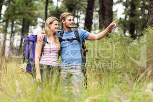 Young happy hiker couple pointing