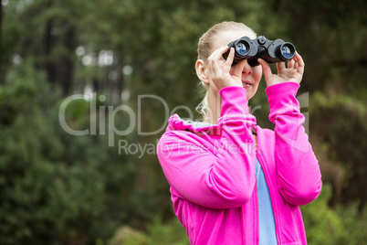 Female hiker looking through the binoculars