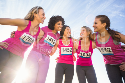 Five smiling runners supporting breast cancer marathon