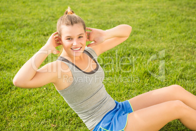 Smiling sporty blonde doing sit ups