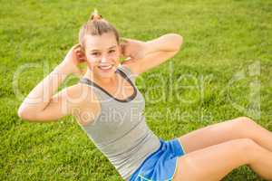 Smiling sporty blonde doing sit ups