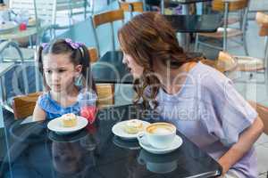 Mother and daughter arguing at table