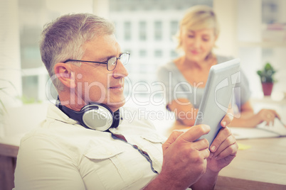 Relaxed businessman looking at his tablet