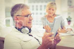 Relaxed businessman looking at his tablet