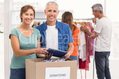 Smiling casual business colleagues with donation box