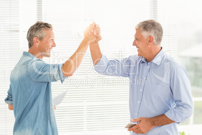 Smiling business colleagues giving high-five