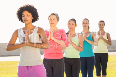 Peaceful sporty women doing prayer position in yoga class