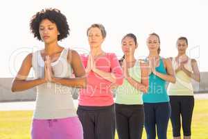 Peaceful sporty women doing prayer position in yoga class