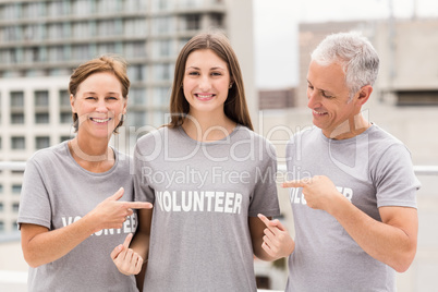 Smiling volunteers pointing on shirt