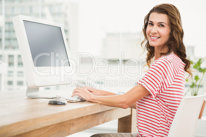 Smiling casual businesswoman working with computer