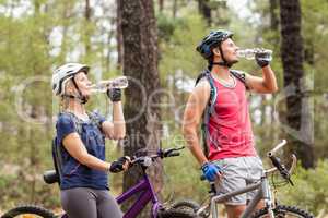 Happy handsome biker couple drinking water