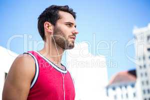 Serious handsome athlete listening to music
