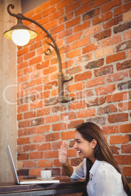 Businesswoman having coffee and working on laptop