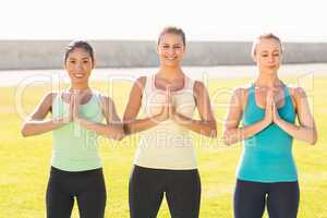 Smiling sporty women doing yoga together