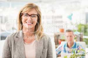 Smiling casual businesswoman in front of her colleague