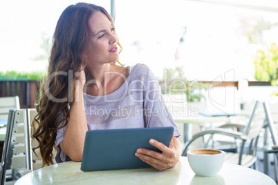 Woman using tablet on cafe terrace