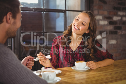 Pretty brunette enjoying cake and coffee with friend