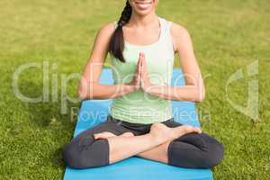 Smiling sporty woman doing the lotus pose