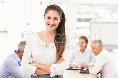 Smiling pretty businesswoman in front of colleagues