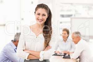 Smiling pretty businesswoman in front of colleagues