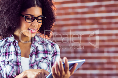Attractive hipster smiling and using tablet