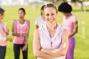 Smiling blonde wearing pink for breast cancer in front of friend