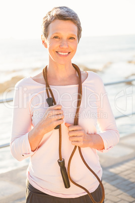 Smiling sporty woman with skipping rope