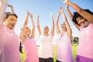 Smiling women wearing pink for breast cancer and cheering